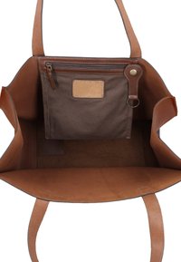 Sac cabas en cuir marron avec intérieur en suède, comprenant une pochette en tissu zippée fixée à l'intérieur et deux bretelles plates.