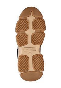 Sohle eines Sneakers mit einer Gummigummisohle und einem Zickzack-Profil. Schwarze Akzente an den Rändern mit einem Etikett, das "STEVE MADDEN" liest.