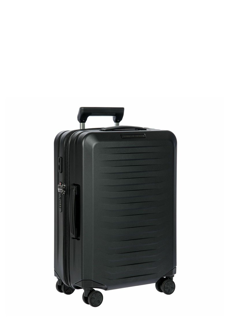 Valise rigide noire avec des rainures verticales, poignée rétractable, quatre roues pour la mobilité et fermeture éclair. Design durable pour les voyages.