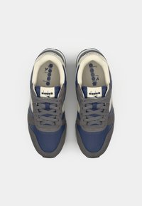 Scarpe sportive con un design blu navy e grigio, realizzate in rete e suede. Presentano lacci, suola in gomma e una fodera interna color crema.