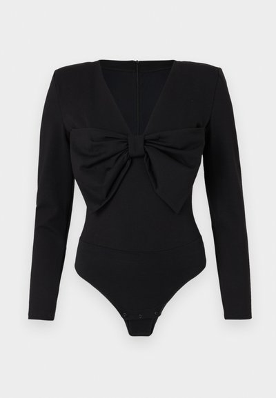 Μαύρο κορμάκι με μακριά μανίκια, βαθύ V-ντεκολτέ και υπερμεγέθη φιόγκο μπροστά. Φτιαγμένο από λείο, ελαστικό ύφασμα με κούμπωμα στο κάτω μέρος.