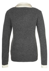 Šedý pletený svetr s dlouhými rukávy a bílou košilí s límečkem pod ním. Žebrovaný výstřih a jemná textura po celém svetru.