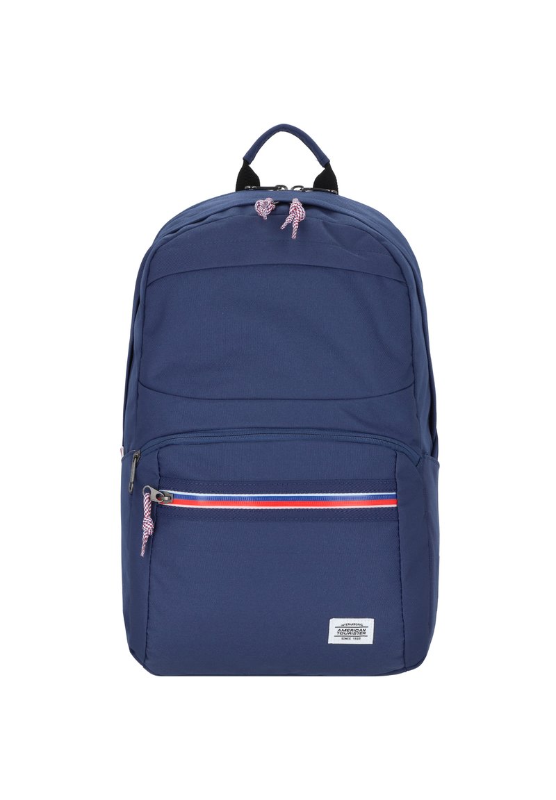 Navy backpack made of durable fabric with a smooth texture, featuring a front zipper pocket with red and white stripe accents and a top handle.