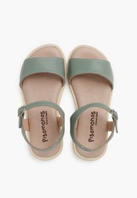 Green faux leather sandals with a wide strap and ankle buckle, featuring a beige sole and textured insole, branded "Pisamonas" inside.