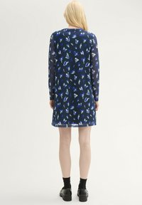 Langärmliges Kleid in Marineblau mit floralem Muster in Blau- und Grüntönen. Hergestellt aus leichtem Stoff, mit geradem Schnitt und rundem Ausschnitt.