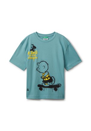 Türkisfarbenes T-Shirt mit einem schwarz-gelben Grafikdesign von Charlie Brown, der skateboardet, und dem Text "König der Straßen".