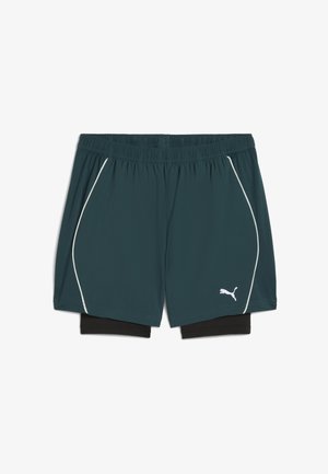 Dunkelpetrolfarbene Puma-Trainingsshorts mit schwarzem inneren Kompressionslayer, elastischem Bund und weißen Paspeln an den Seiten vor einem weißen Hintergrund.