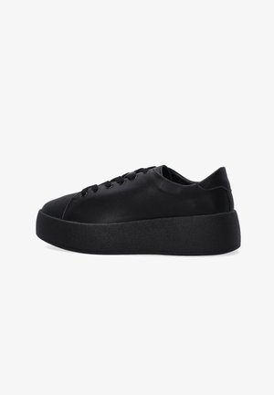 Czarny skórzany sneaker na platformie z grubą podeszwą, z przodem na sznurowanie i gładkim, minimalistycznym designem, pokazany w profilu bocznym na białym tle.