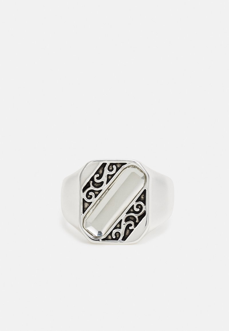 Anel em tom prateado com uma pedra retangular clara e um intricado design em filigrana preta, apresentando uma banda lisa com um acabamento polido.