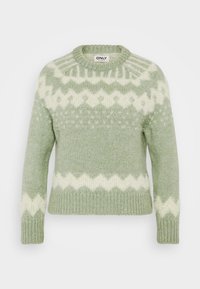 Jasnozielony sweter z miękkiego dzianinowego materiału. Posiada okrągły dekolt, długie rękawy oraz dekoracyjny biały geometryczny wzór.