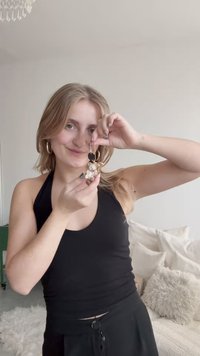 Átlátszó akril kulcstartó nyuszis mintával, arany színű fém részekkel és fekete kör alakú díszítéssel, egy fekete atléta felsőt viselő személy kezében.