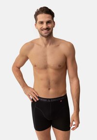 Svarta boxershorts med en mjuk, elastisk midja som har "DANISH ENDURANCE"-logotypen i grått. Materialet är glatt och stretchigt.