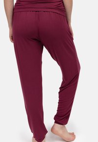 Bordeaux jersey loungebroeken met een ontspannen pasvorm, elastische tailleband en een gladde textuur, met een tapered leg ontwerp.