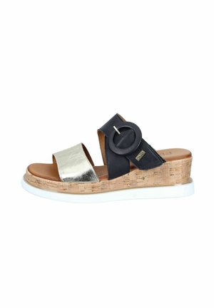 Wedge sandal with cork sole, metallic silver toe strap, black ankle strap with large round buckle, and white rubber outsole.