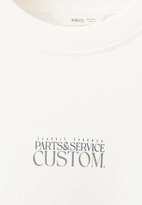 Biela mikina s rebrovaným okrúhlym výstrihom. Obsahuje potlačený textový dizajn: "CLASSIC ESSENCE PARTS & SERVICE CUSTOM" v námorníckej modrej a sivej farbe.