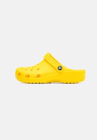 Yellow rubber clogs featuring an open design, ventilation holes, a flexible back strap, and textured sole for grip.