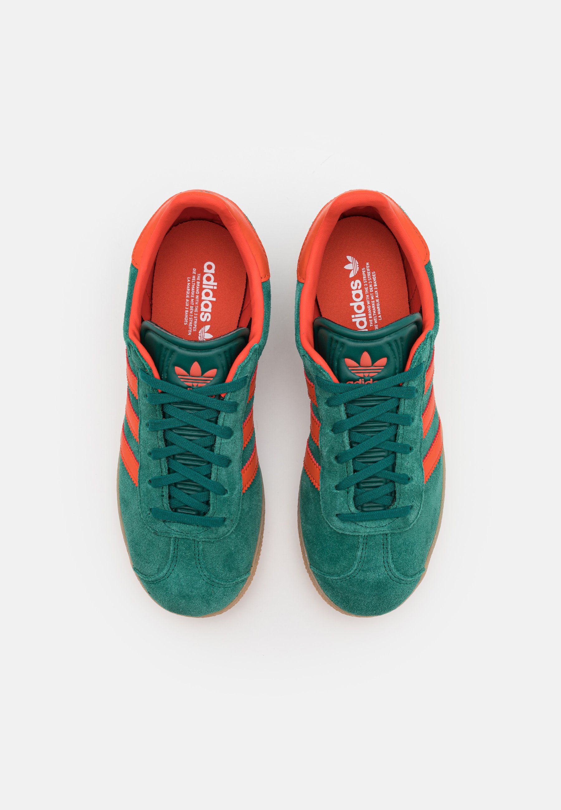 green and red adidas trainers