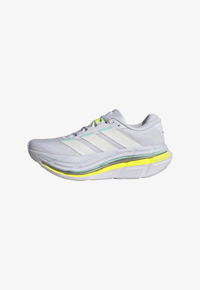Chaussure de course blanche avec trois bandes blanches, semelle épaisse et rembourrée avec des accents translucides et jaunes, et fermeture à lacets sur fond blanc.