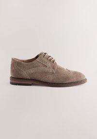 Chaussure habillée en daim beige avec détails brogues, design à lacets et semelle en cuir marron. Finition lisse et silhouette courbée.