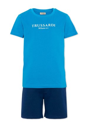 Niebieska koszulka Trussardi z krótkim rękawem z napisem „TRUSSARDI Milano 1911” w zestawieniu z granatowymi szortami.