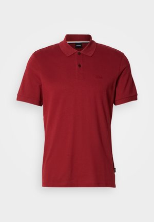 Red polo shirt made of soft cotton fabric. Features a classic collar, two-button placket, and embroidered logo on the chest.