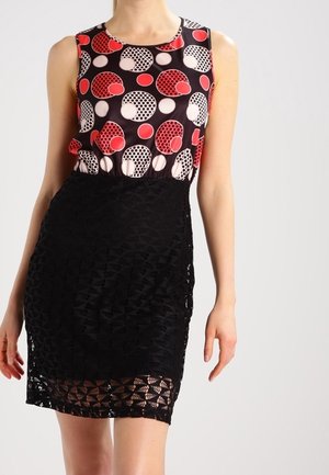 Sukienka bez rękawów z wzorzystą górą, na której znajdują się czerwone, białe i czarne koła, oraz z teksturowaną czarną koronkową spódnicą sięgającą ponad kolano.