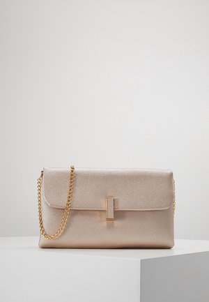 Suorakaiteen muotoinen metallinen kultainen clutch-laukku, jossa on kuvioitu pinta, läppäsuljin ja kultainen ketjuhihna, esillä valkoisella jalustalla.