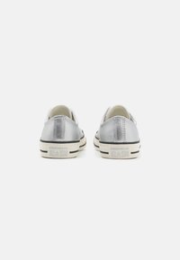 Stříbrné tenisky Converse All Star s hladkým metalickým povrchem, kontrastními černými gumovými podrážkami s bílými akcenty a logem na patě.
