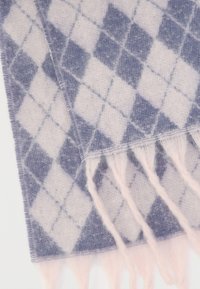 Ελαφρύ κασκόλ με μοτίβο διαμαντιού σε απαλό ροζ και σκούρο μπλε αποχρώσεις. Οι άκρες είναι με κρόσσια για επιπλέον υφή.