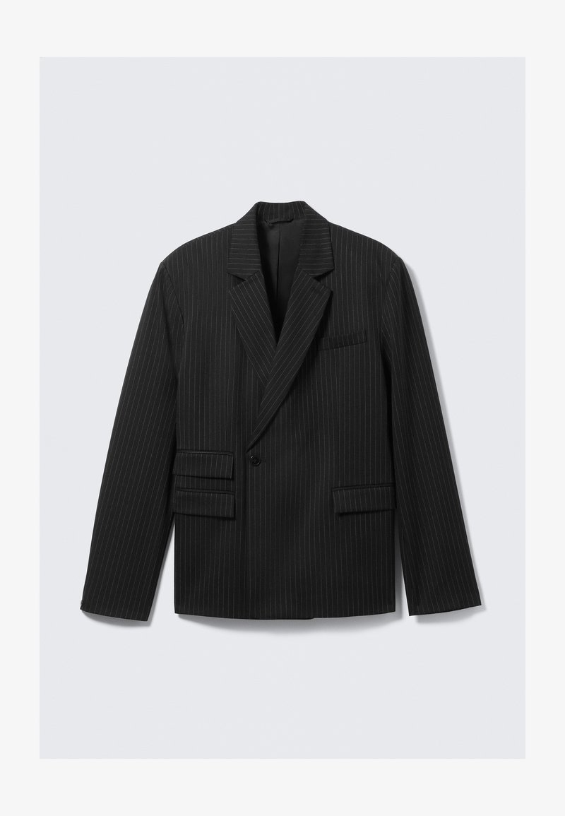 Μαύρο σακάκι με ρίγες και κέντρα από τις γωνίες, κλείσιμο με έναν κουμπί και δύο κατωτέρω τσέπες με flap. Διαθέτει μακριά μανίκια και δομημένη εφαρμογή.