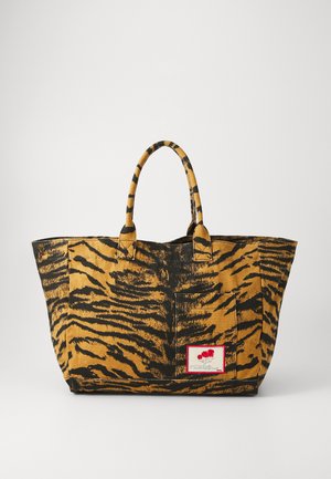 Kangas kottis koti, millel on tiigri trükimuster, mustad triibud kuldse-kollase tausta peal. Sisaldab kaht käepidet ja punast logot.