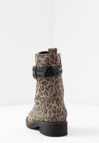 Botas de tobillo de estampado de leopardo, hechas de ante, con una correa de hebilla negra, punta redonda y un bajo tacón de madera. Superficie texturizada con patrones.