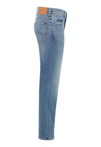 Ljusblå denimjeans visade från sidan, med en bakficka med sömmar och en brun läderlapp vid midjan.