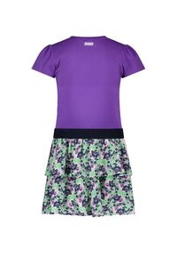 Fioletowa bluzka z krótkim rękawem z marszczoną spódnicą w kwiaty, z fioletowym i zielonym wzorem oraz czarnym paskiem w talii. Wykonana z miękkiej bawełny.