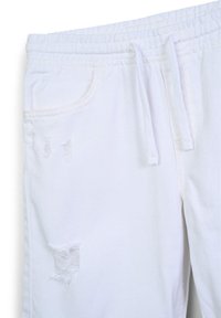 Pantaloni da jogging bianchi con elastico in vita, cordino, due tasche laterali, dettagli strappati e morbido tessuto di cotone.