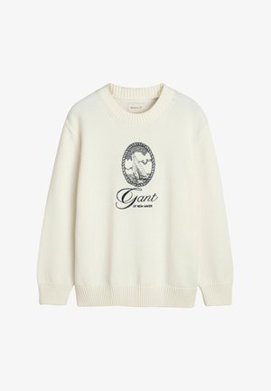 Krémový pletený svetr s kulatým výstřihem, ribbovanými manžetami a lemem, s námořnickým vyšívaným logem zobrazujícím plachetnici a název značky.
