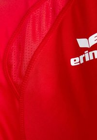 Camisa deportiva roja con un patrón texturizado; presenta un acabado suave y un logo blanco con la palabra "erin" en el frente.