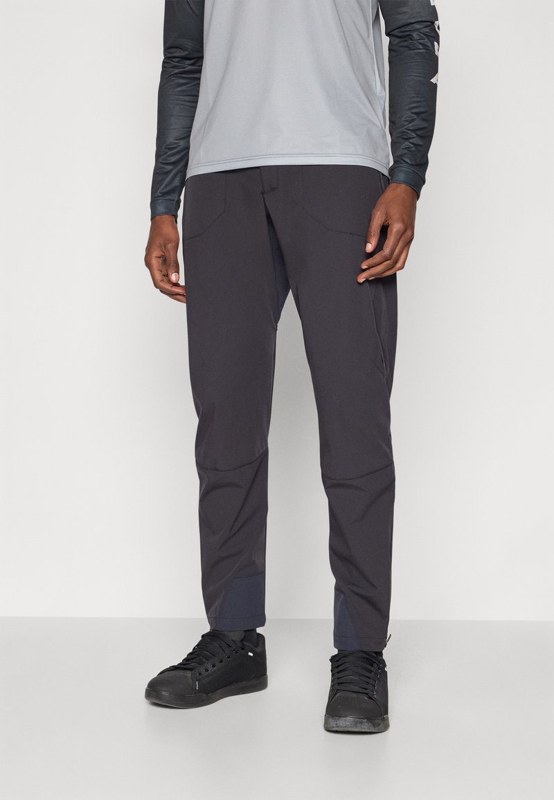 Leichte, dunkelgraue Herren-Hose mit schmalem Schnitt, zwei vorderen Taschen und marineblauen Bündchen, aus dehnbarem Synthetikstoff gefertigt.