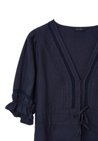 Blusa blu navy con scollatura a V, bordo in pizzo decorativo lungo il collo e le maniche, maniche a sbuffo 3/4 con polsini arricciati e chiusura anteriore con fiocco.