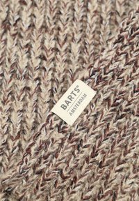 Gebreide beige sjaal met donkerbruine en witte vlekken. Voorzien van een visgraatpatroon en een stoffen label met de tekst "BARTS AMSTERDAM."