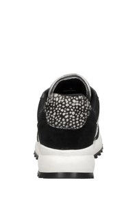 Svart idrottssko med en strukturerad grå och vit prickig hälaccent, en övre del i mesh och en vadderad vit sula.