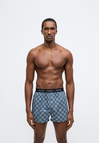 Μπόξερ σορτς με μπλε σχέδιο και λογότυπο "HUGO" στη μαύρη ζώνη μέσης. Διαθέτουν άνετη εφαρμογή και απαλό, ελαφρύ ύφασμα.