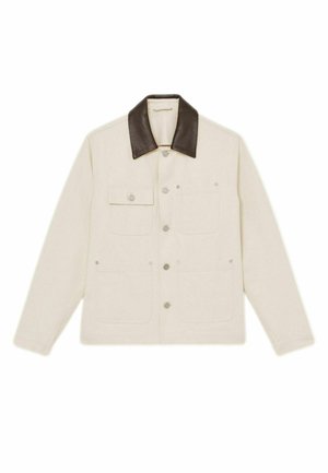 Giacca beige con colletto in pelle marrone, numerose tasche frontali e bottoni a pressione. Il tessuto sembra robusto con una finitura testurizzata.