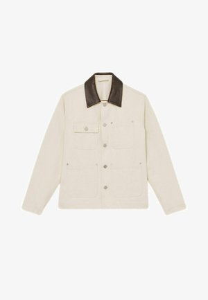 Giacca beige con colletto in pelle marrone, numerose tasche frontali e bottoni a pressione. Il tessuto sembra robusto con una finitura testurizzata.