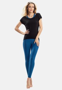 Black short-sleeve top with blue accents, paired with tight, vibrant blue leggings. Smooth texture and fitted design.