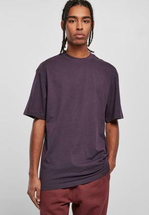 Camiseta de manga corta con cuello redondo en algodón de color morado oscuro. Corte relajado con costuras mínimas y sin patrones o gráficos visibles.