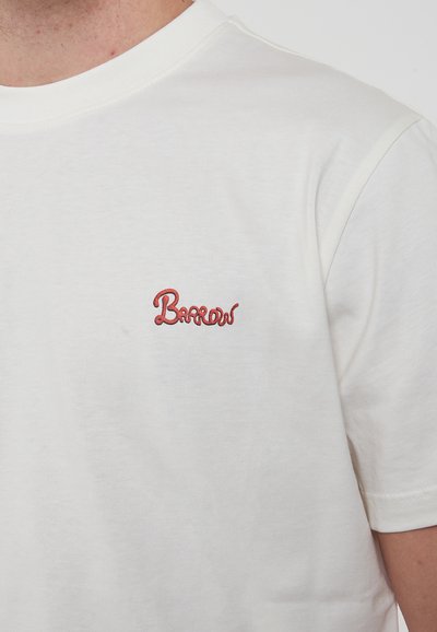 T-shirt bianco in cotone con un logo "Barrons" ricamato di colore rosso sul lato sinistro del petto. Maniche corte e design classico a girocollo.