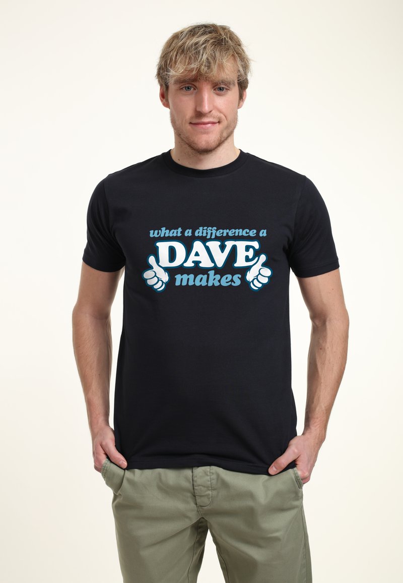Camiseta de algodón negra con texto azul que dice "qué diferencia hace un DAVE", con dos gráficos de pulgares arriba en el frente. Mangas cortas, cuello redondo.