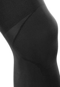 Black knee-high compression sock with a ribbed texture, smooth finish, and contoured shape designed for support and comfort.