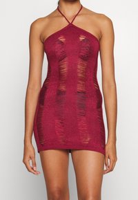 Virkat halterminiklänning i burgundy med skärningar, med öppna vävningar och en figurnära design. Justerbar nackrem.